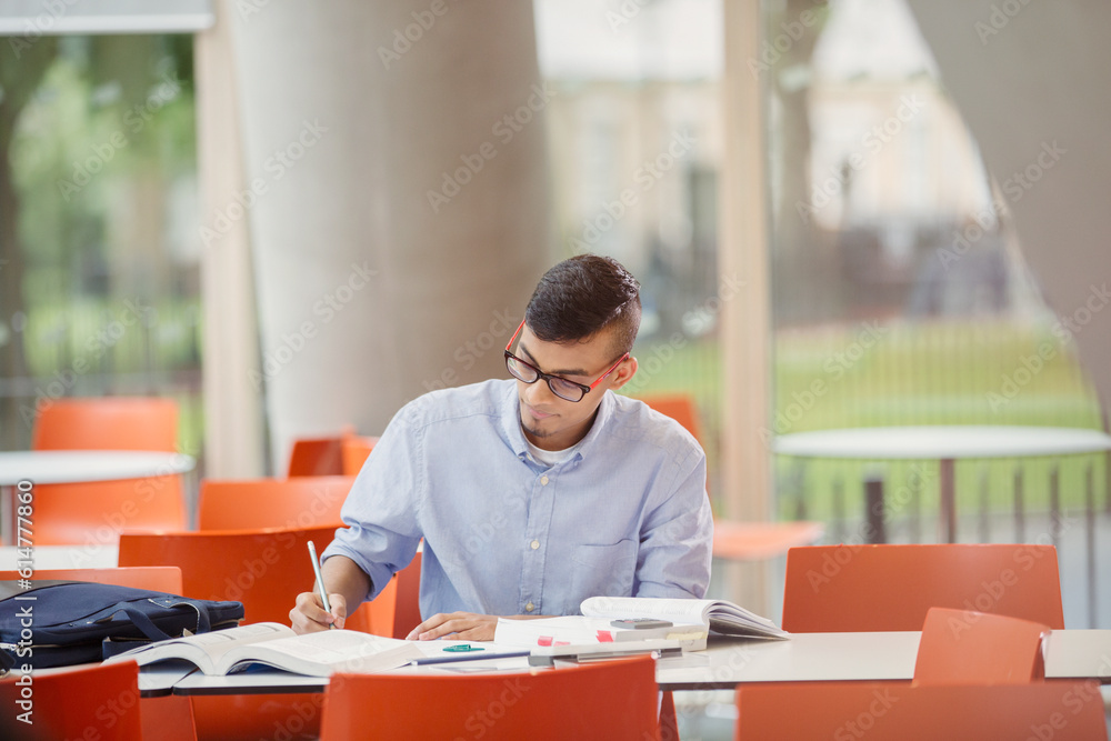 Male college student studying at table Male college student studying at table
