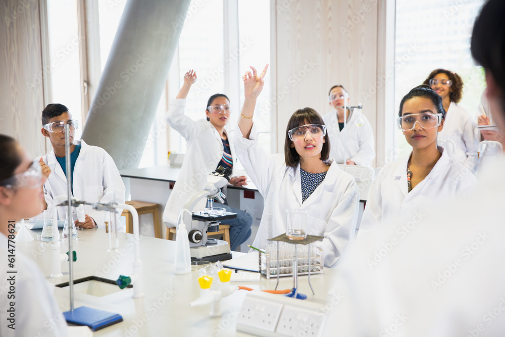 College students raising hands in science laboratory classroom College students raising hands in science laboratory classroom