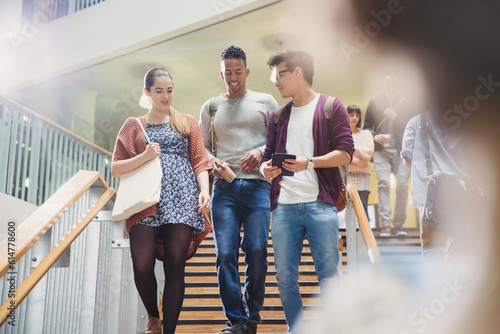 Foto College students talking and descending stairway