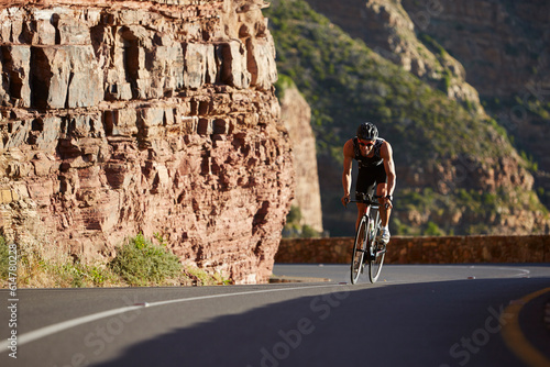Male triathlete cycling uphill photo