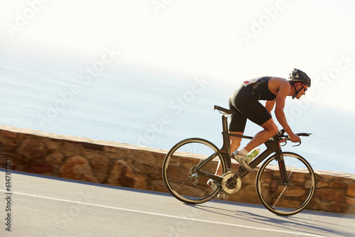 Papier peint Male triathlete cyclist racing on ocean road