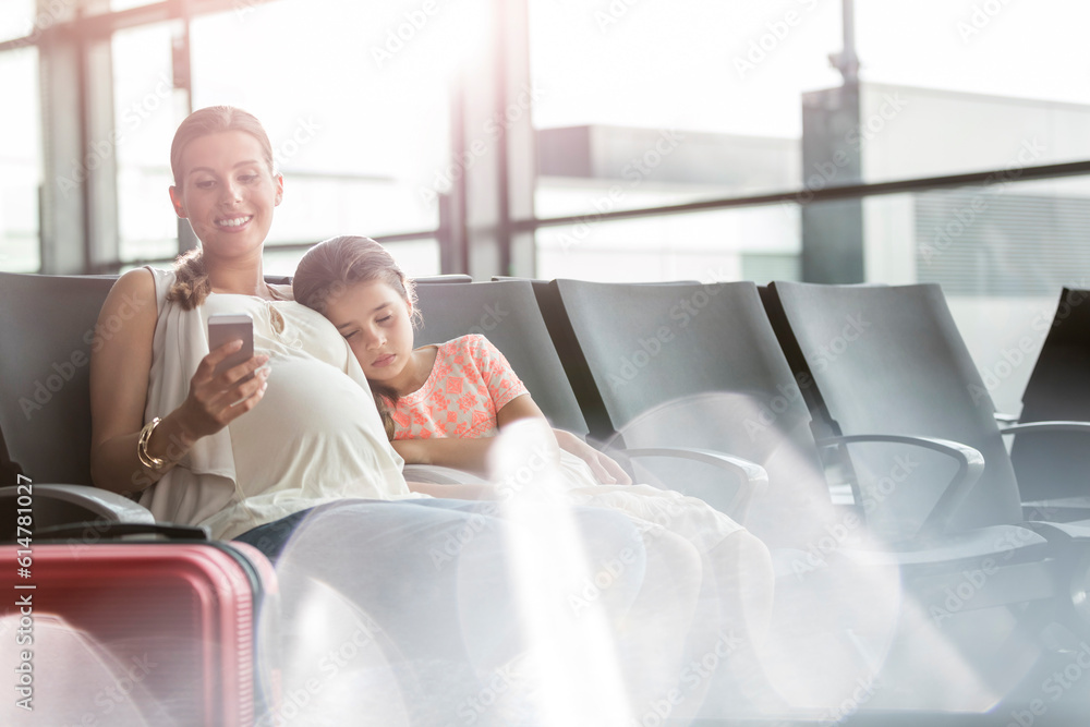 Pregnant mother cell phone sleeping daughter in airport departure area Pregnant mother cell phone sleeping daughter in airport departure area