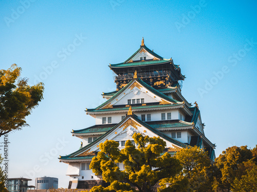 Majestic Osaka Castle stands tall, surrounded by vibrant cherry blossoms. Its elegant architecture reflects centuries of Japanese history and culture. Osaka Castle, a grand symbol of Japan