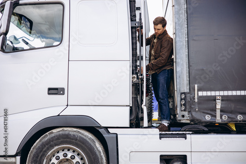 Truck driver stopped on the road reparing his lorry