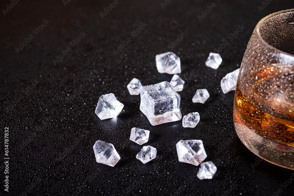 whiskey with ice on a wooden table. Reasonable consumption of alcoholic beverages whiskey with ice on a wooden table. Reasonable consumption of alcoholic beverages
