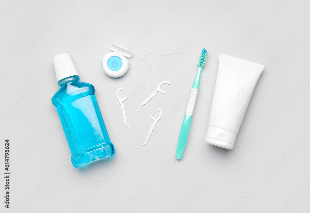 Rinse, dental floss, brush and tube of toothpaste on grey background Rinse, dental floss, brush and tube of toothpaste on grey background