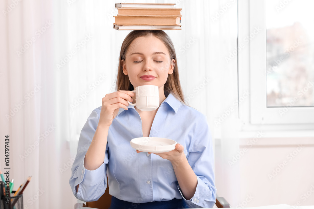 Young businesswoman with books drinking coffee in office. Balance concept Young businesswoman with books drinking coffee in office. Balance concept