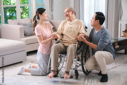 Asian family person health care and insurance at home concept, man and daughter woman take care support to senior elderly father patient in wheelchair together, having smile in happy love lifestyle