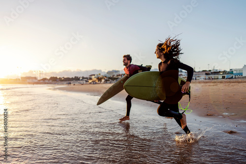 Photography Surfers running to the waves in ocean.