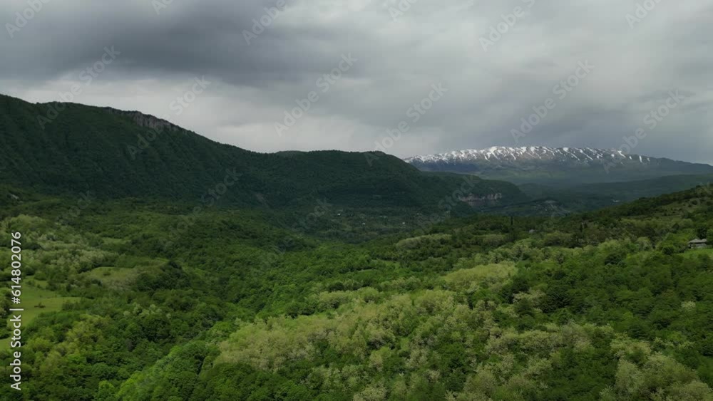 The snow-covered peaks. Forest park among the mountains. Beautiful mountain ranges with snow-covered peaks. Rainy weather in the mountains. Drone views. View of the mountains from a drone. The snow-covered peaks. Forest park among the mountains. Beautiful mountain ranges with snow-covered peaks. Rainy weather in the mountains. Drone views. View of the mountains from a drone.