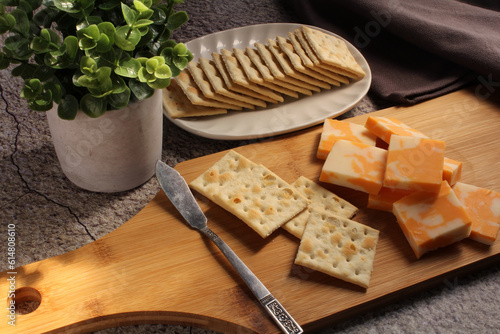 Canvas-taulu Cheese and crackers on a wooden breadboard