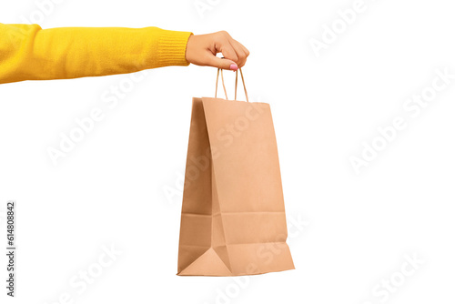 Woman hand holding paper shopping bag isolated on transparent background. Discounts and sale of concept.