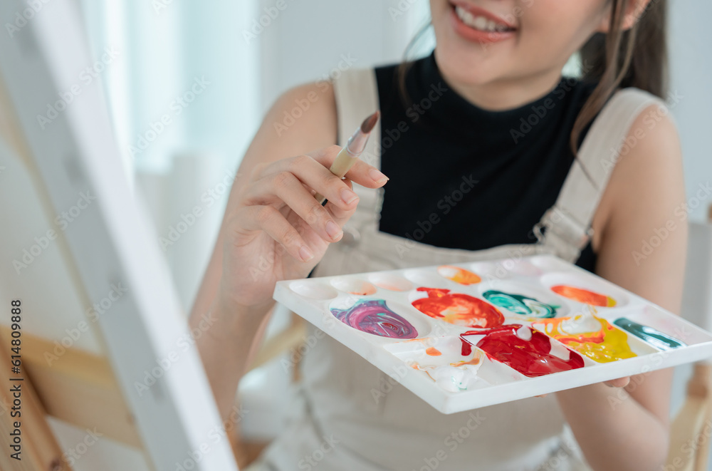 Fototapeta premium Professional female artist girl use paintbrush in abstract art for create masterpiece. painter paint with watercolors or oil in studio house. beautiful woman enjoy painting as hobby. work recreation