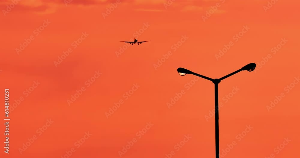 Golden orange sky sunset with airplane flying high in air Golden orange sky sunset with airplane flying high in air