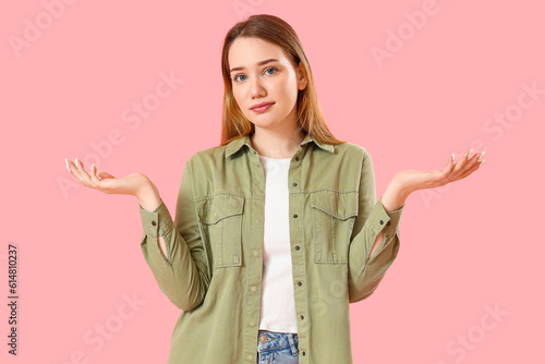 Upset young woman on pink b...