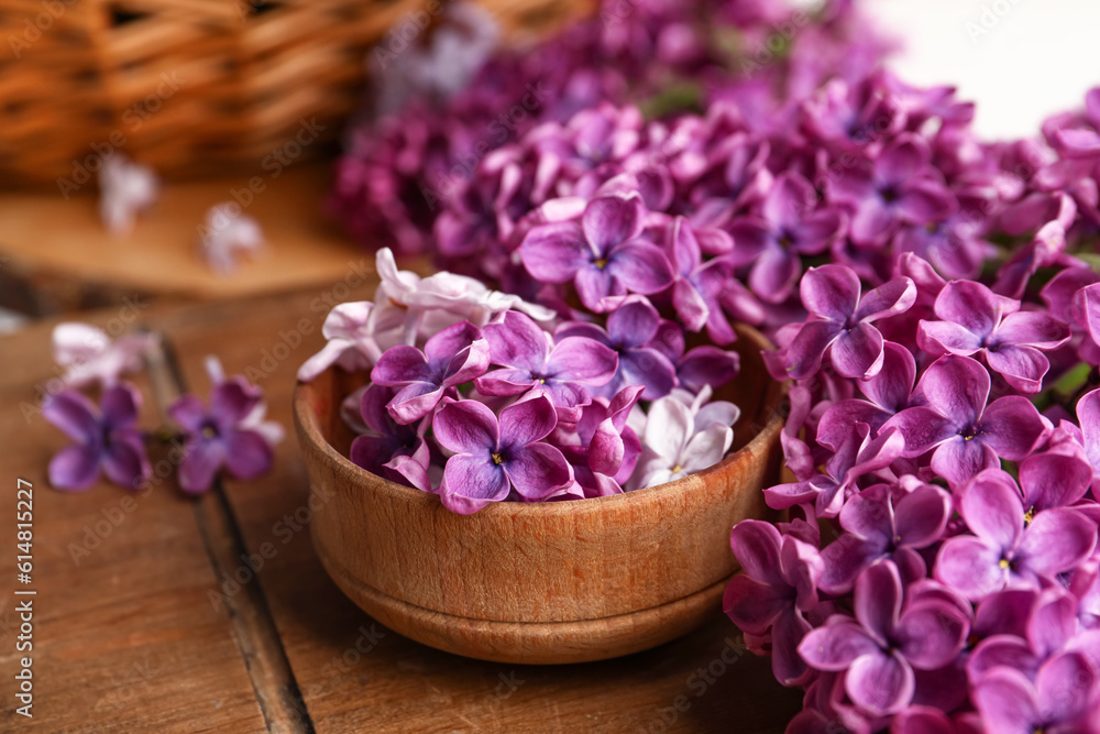 Bowl of beautiful fragrant lilac flowers on wooden table Bowl of beautiful fragrant lilac flowers on wooden table