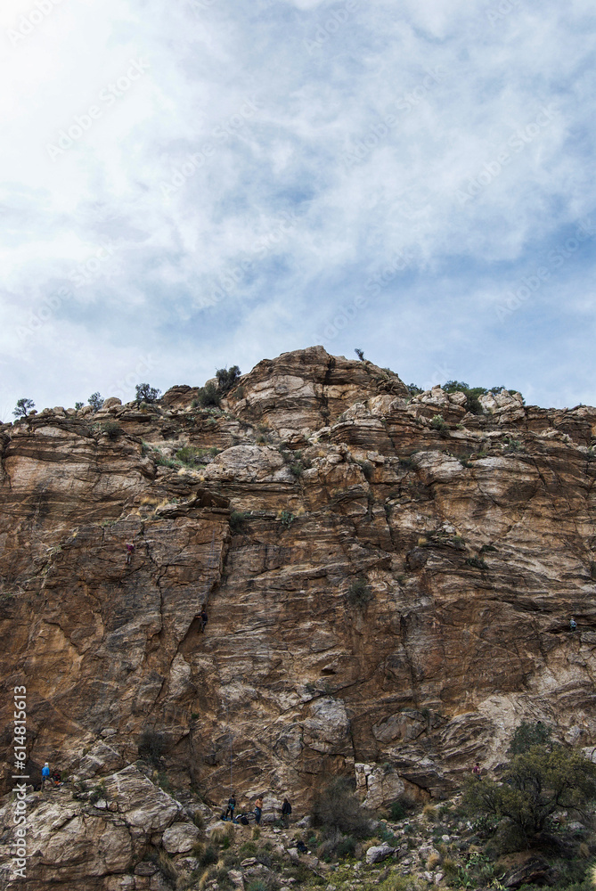 Rock climbers at the bottom of steep rocky cliff in the Sonora Desert, Arizona