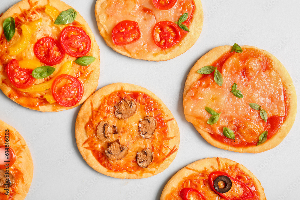 Different tasty mini pizzas on grey background Different tasty mini pizzas on grey background