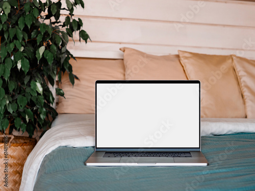 Laptop blank screen on bed in country house, mockup, template photo
