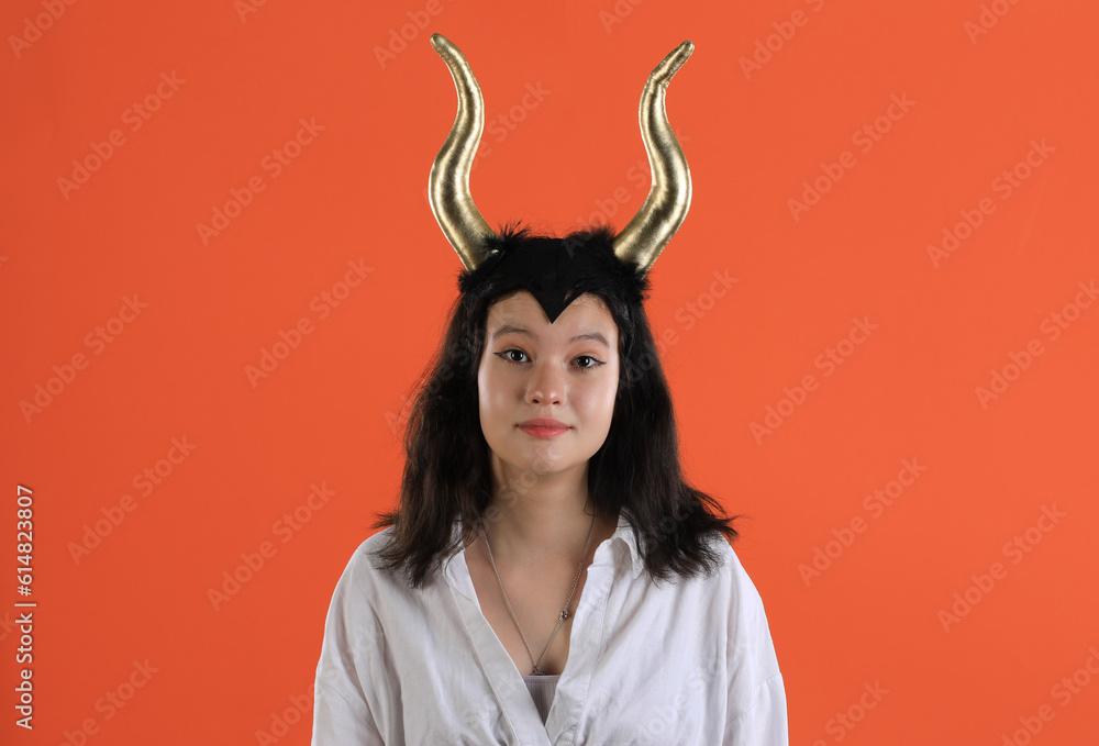 girl with halloween demon horns on orange background girl with halloween demon horns on orange background