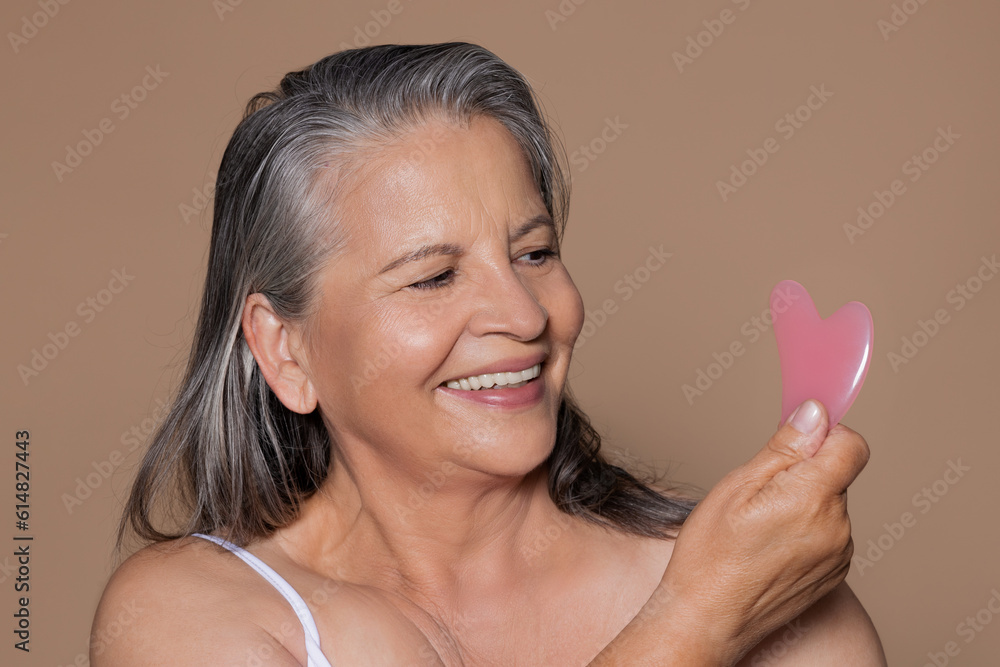 Portrait of happy european elderly woman with gray hair uses jade gouache petal Portrait of happy european elderly woman with gray hair uses jade gouache petal