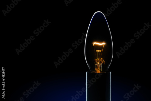 Light bulb with  tungsten filament burning in dark