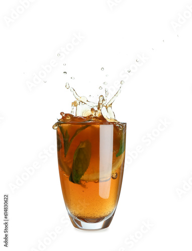 Glass of ice tea with splashes on white background