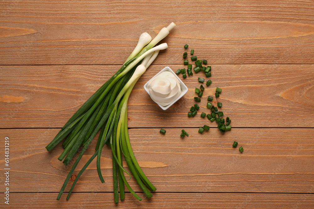 Bowl of tasty sour cream and sliced green onion on wooden background Bowl of tasty sour cream and sliced green onion on wooden background