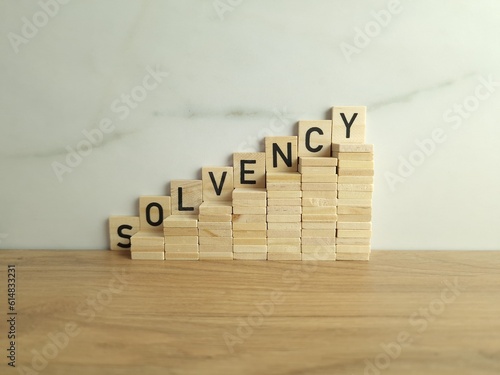 Wooden stairs up with word solvency. Creditworthiness, banking conditions, credit funds photo