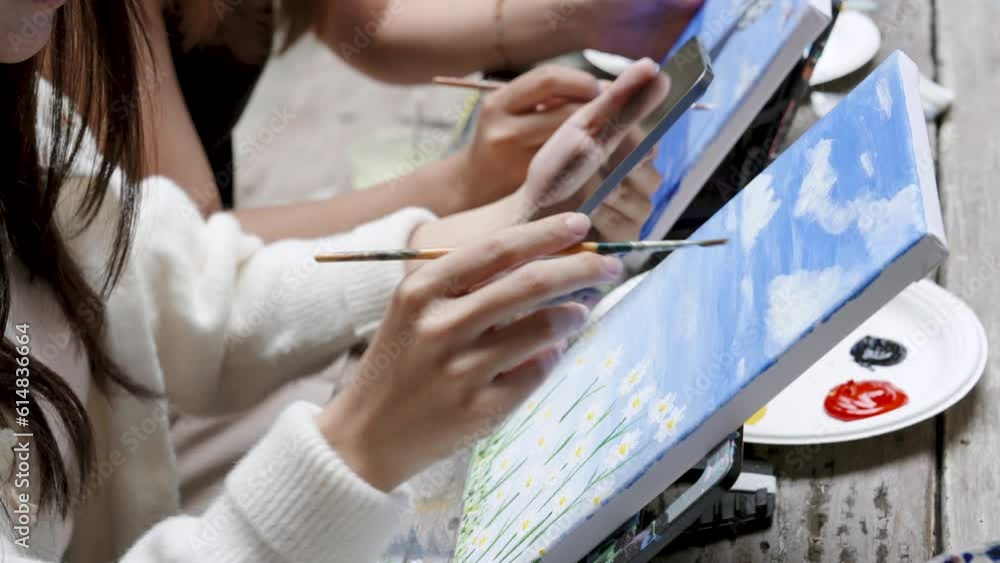 Close-up hands Asian woman, handling pointy brush is painted piece cloth, It was favorite daisy flower pattern, use white paint sky gives it more dimensions use white paint sky as floating clouds. Close-up hands Asian woman, handling pointy brush is painted piece cloth, It was favorite daisy flower pattern, use white paint sky gives it more dimensions use white paint sky as floating clouds.