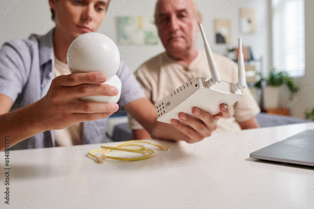 Grandson helping grandfather to install surveillance camera at home Grandson helping grandfather to install surveillance camera at home
