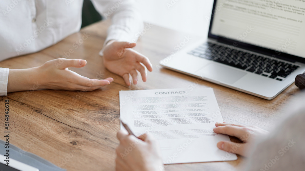 Business people signing contract papers while sitting at the wooden table in office, closeup. Partners or lawyers working together at meeting. Teamwork, partnership, success concept Business people signing contract papers while sitting at the wooden table in office, closeup. Partners or lawyers working together at meeting. Teamwork, partnership, success concept