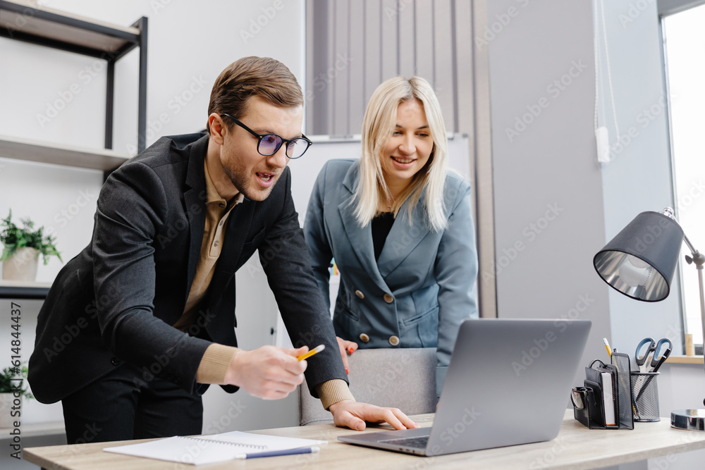 Concentrated male businessman looking at computer monitor, working with a young female worker on a project, people holding a video meeting with a client or interviewing a job candidate. Concentrated male businessman looking at computer monitor, working with a young female worker on a project, people holding a video meeting with a client or interviewing a job candidate.