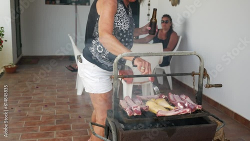 happy elderly lady cooking on a barbecue together with her family