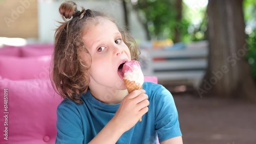 Portrait of boy eating cone ice cream. Child licking ice cream. photo