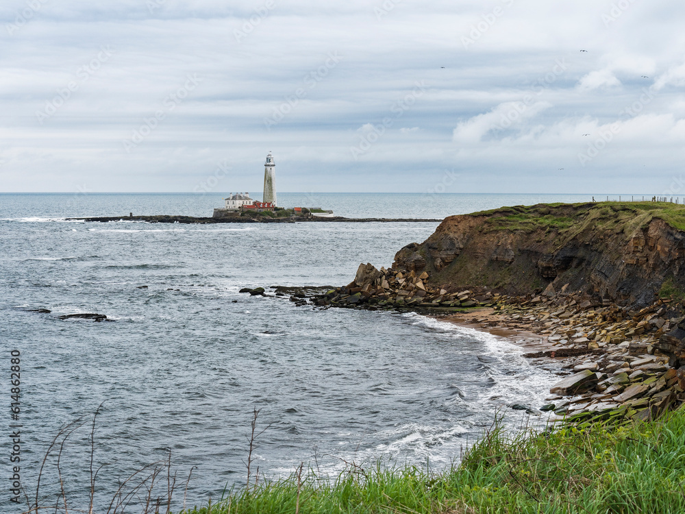 Erosion of cliffs on the north east coast of England with St Mary's lighthouse