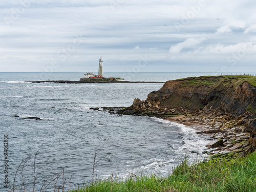 Erosion of cliffs on the north east coast of England with St Mary's lighthouse