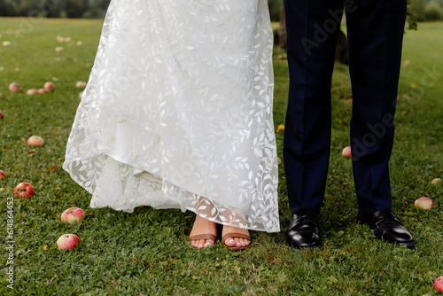 Bride and groom standing together in apple orchard.