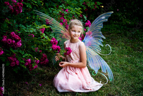 Fotografía little beautiful girl in a fairy costume of butterfly with wings sitting on the