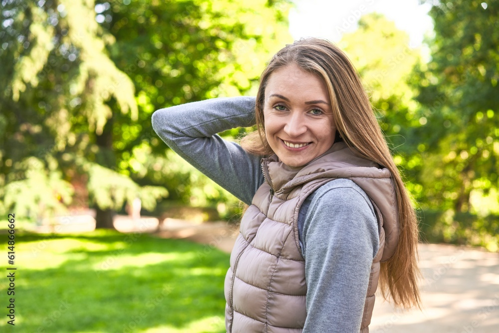 Joyful middle-aged woman, radiating happiness while posing in the park. Joyful middle-aged woman, radiating happiness while posing in the park.
