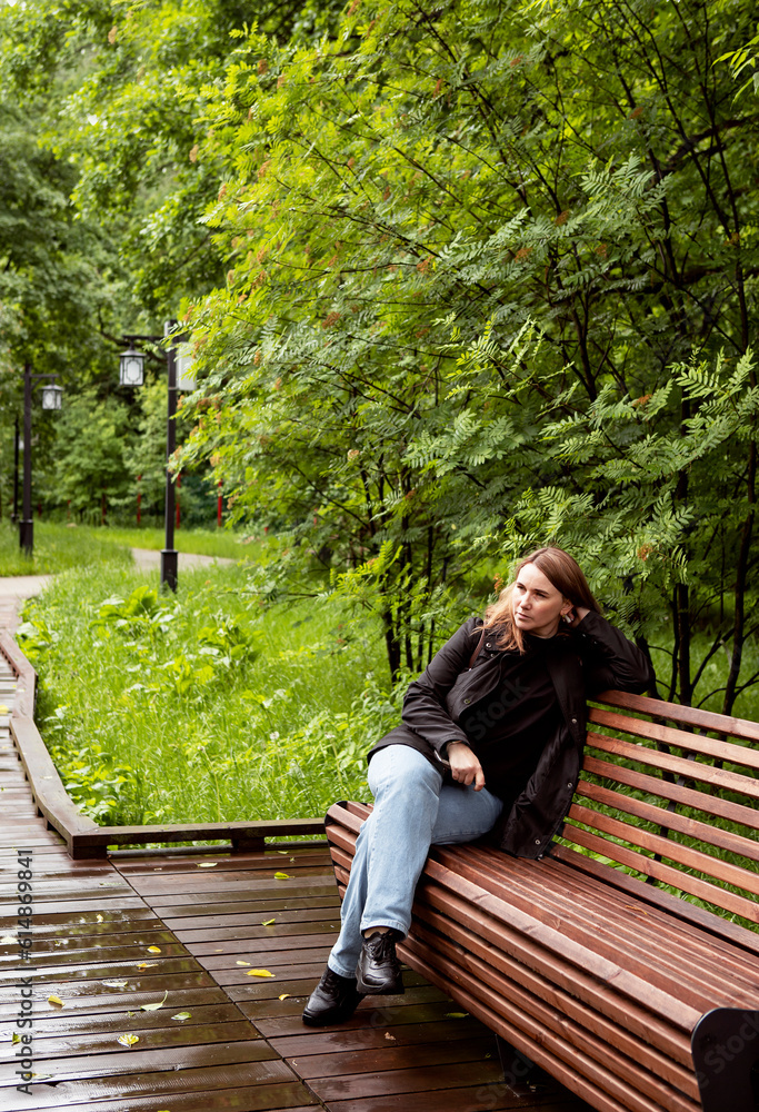 Fototapeta premium young woman walking in the park in the summer in rainy weather