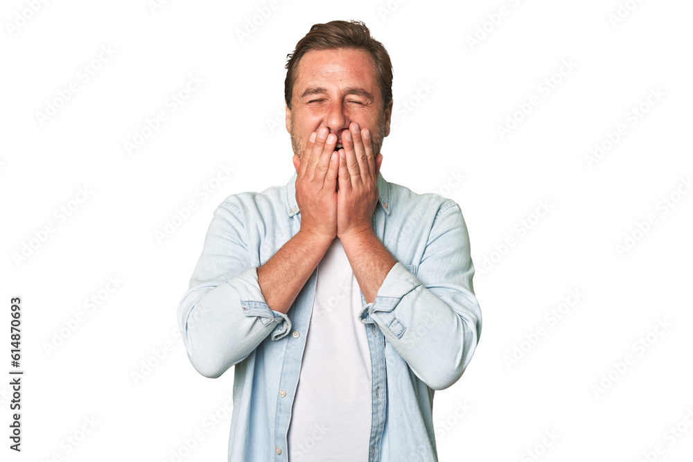 A middle-aged man isolated laughing about something, covering mouth with hands. A middle-aged man isolated laughing about something, covering mouth with hands.