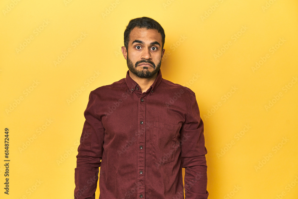 Casual young Latino man against a vibrant yellow studio background, sad, serious face, feeling miserable and displeased. Casual young Latino man against a vibrant yellow studio background, sad, serious face, feeling miserable and displeased.