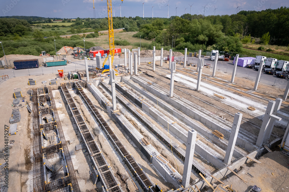 on a construction site concrete pillars are erected for the construction of a factory building on a construction site concrete pillars are erected for the construction of a factory building
