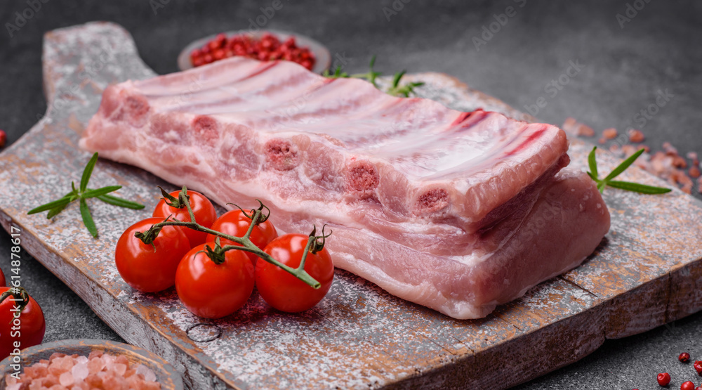Raw pork ribs with meat with salt, spices and herbs Raw pork ribs with meat with salt, spices and herbs