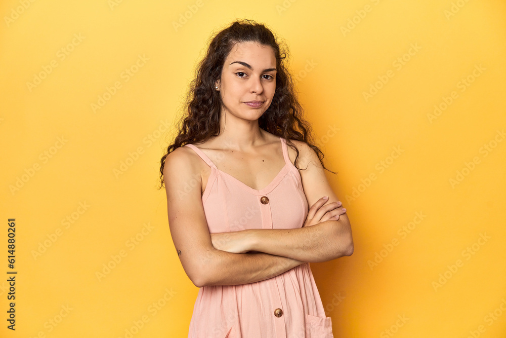 Young Caucasian woman, yellow studio background, suspicious, uncertain, examining you. Young Caucasian woman, yellow studio background, suspicious, uncertain, examining you.