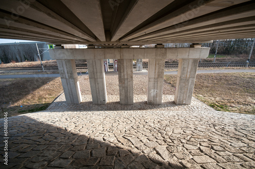 Foto A concrete bridge over the highway illuminated by the sun, a railway underpass under the road