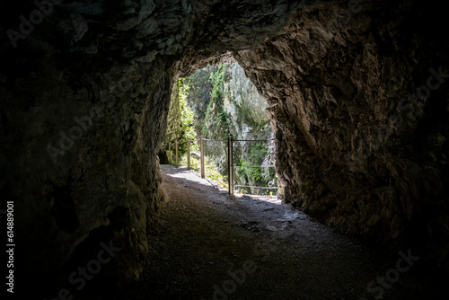 Beautiful tunnel leading through the steep, rocky cliffs of Soca river canyon, popular tourist destination in alpine region of Slovenia