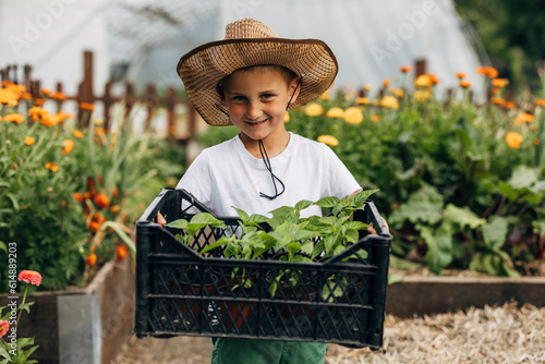 Obraz na plátně Smiling boy enjoys working in the garden.