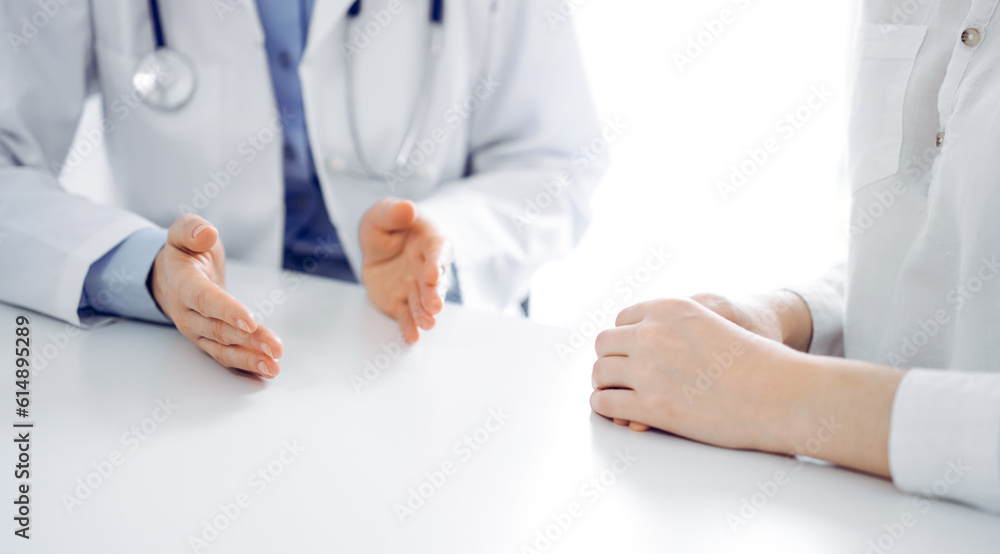 Doctor and patient discussing current health questions while sitting near of each other at the table in clinic, just hands closeup. Medicine concept Doctor and patient discussing current health questions while sitting near of each other at the table in clinic, just hands closeup. Medicine concept